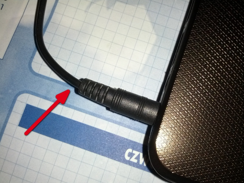 Jack plugged into a laptop with an arrow pointing to the fragile part of the cable